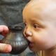 A modern-day infant sipping from a reconstructed feeding vessel of the type analyzed in the new study.